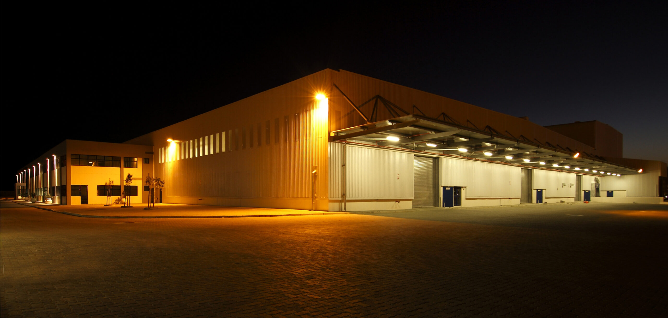 External wide angle view of modern warehouse at night